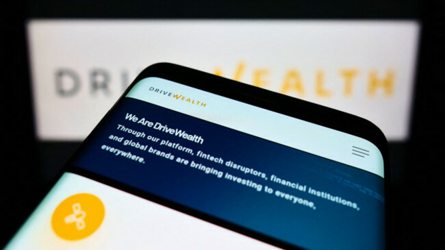 cellphone-with-webpage-of-us-fintech-company-drivewealth-llc-on-screen-in-front-of-business-logo-focus-on-top-left-of-phone-display
