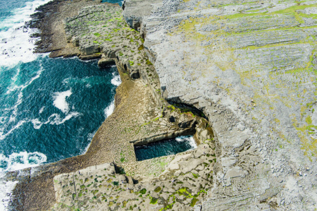 aerial-view-of-famous-poll-na-bpeist-or-the-wormhole-natural-rectangular-shaped-pool-at-the-bottom-of-the-cliffs-south-of-dun-aonghasa-also-known-a