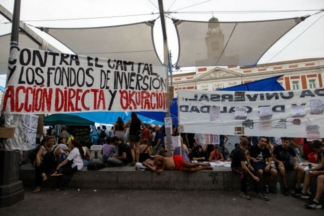 madrid-spain-27th-sep-2026-a-homeless-person-sleeps-amidst-signs-at-the-encampment-in-madrids-puerta-del-sol-second-day-of-the-encampment-at-madrids-puerta-del-sol-dozens-of-tents-remain-set-u