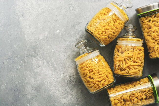 flat-lay-different-uncooked-pasta-in-a-glass-jar-on-a-gray-background-copy-space-top-view