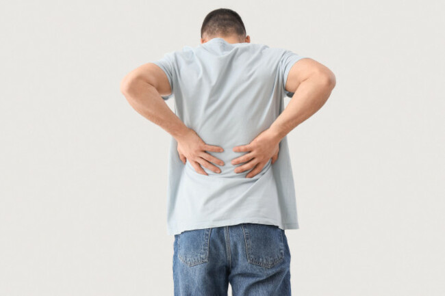young-man-suffering-from-back-pain-on-white-background