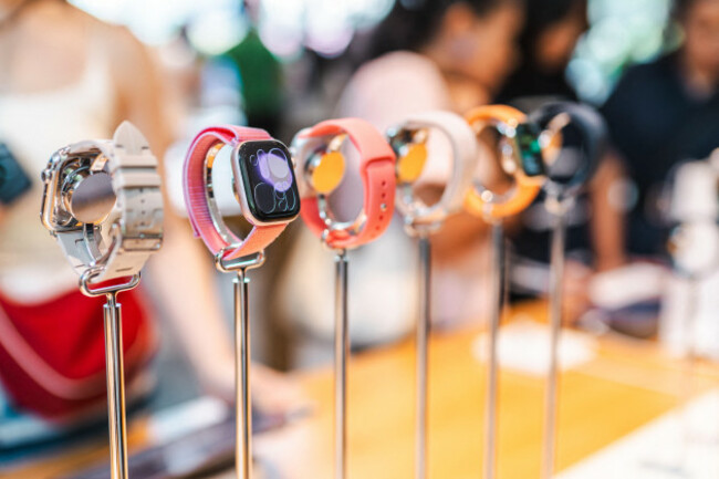 bangkok-thailand-may-4-2026-apple-watches-stand-on-display-poles-inside-an-apple-store-with-people-softly-blurred-in-the-background