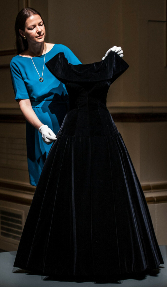 embargoed-to-0001-friday-july-22-curator-caroline-de-guitaut-adjusts-an-evening-gown-by-norman-hartnell-worn-by-queen-elizabeth-ii-in-1956-when-she-met-marilyn-monroe-during-a-press-preview-for-fashi
