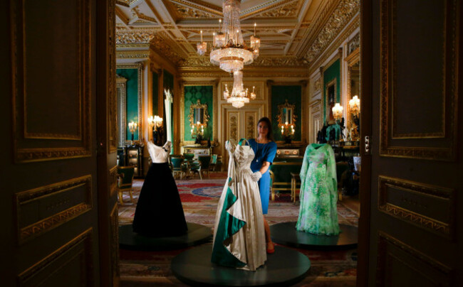 curator-caroline-de-guitaut-adjusts-an-evening-gown-by-ian-thomas-made-in-1979-in-chiffon-and-silk-and-worn-by-britains-queen-elizabeth-ii-during-a-press-preview-of-an-exhibition-entitled-fashion
