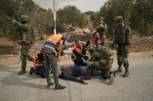 palestinian-medics-and-an-israeli-soldier-attend-to-a-palestinian-man-shot-by-israeli-soldiers-following-a-settler-attack-on-palestinians-harvesting-olives-in-the-west-bank-village-of-abu-falah-frida