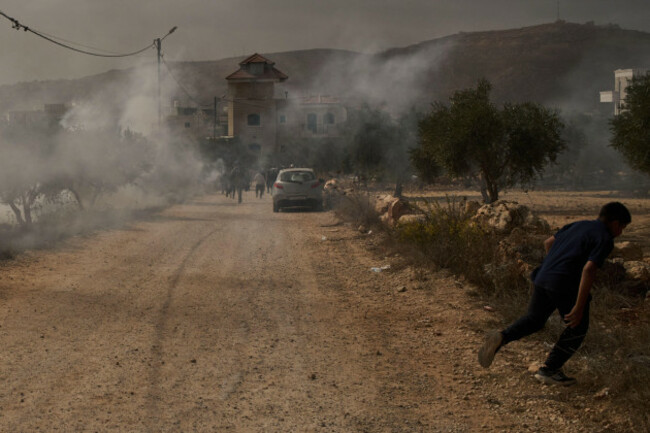 a-palestinian-youth-runs-from-tear-gas-fired-by-members-of-israeli-forces-following-a-settler-attack-during-the-olives-harvest-in-the-west-bank-village-of-abu-falah-friday-oct-16-2026-ap-photol
