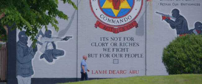 Réalt na Mara (Former Star of the Sea player, Raymond McCord walks past a loyalist mural the Rathcoole Estate in North Belfast where he grew up)
