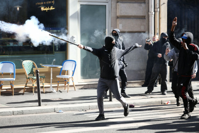 a-black-bloc-protester-throws-fireworks-while-the-french-republican-security-corps-crs-compagnies-republicaines-de-securite-and-brav-m-troops-respond-during-clashes-prior-to-the-start-of-a-demonst