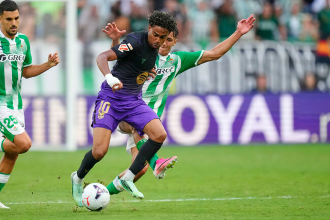 barcelonas-lamine-yamal-centre-challenges-for-the-ball-with-betis-facundo-bernal-during-the-spanish-la-liga-soccer-match-between-real-betis-and-barcelona-in-seville-spain-saturday-oct-17-2026