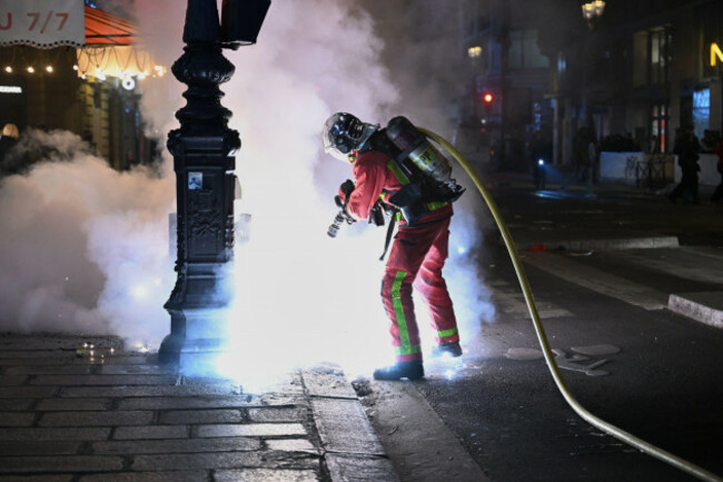 a-firefighter-extinguishes-a-fire-during-clashes-between-protestors-and-police-in-paris-sunday-oct-18-2026-ap-photoemma-da-silva