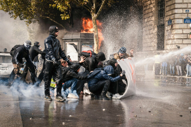 paris-france-17th-oct-2026-protesters-shelter-behind-a-shield-as-a-water-cannon-sprays-them-in-paris-france-on-october-17-2026-protesters-gathered-in-paris-as-part-of-a-nationwide-mobilisation