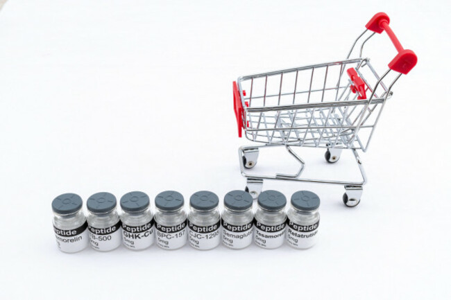 peptides-in-vials-on-a-white-background-with-a-miniature-shopping-cart