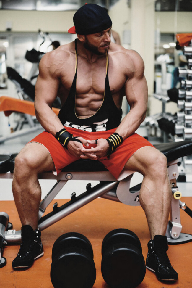 body-builder-sitting-on-bench-in-gym