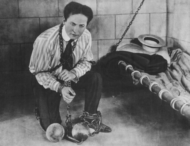 promotional-photo-c1898-of-magician-escapologist-harry-houdini-1874-1926-restrained-in-chains-and-locked-in-a-cell