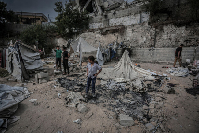 displaced-palestinias-stand-among-burned-tent-remains-and-scattered-debris-near-the-shujaiyya-junction-in-eastern-gaza-city-gaza-strip-palestine-on-october-26-2026-according-to-gazas-public-wor